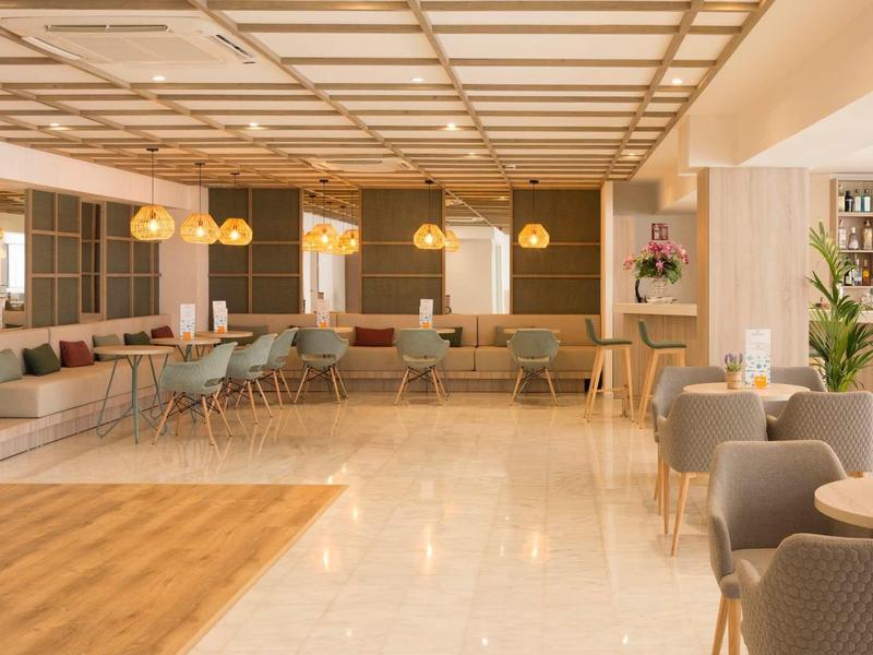 Grand salon d'hôtel avec sièges modernes, éclairage chaleureux et accents en bois.