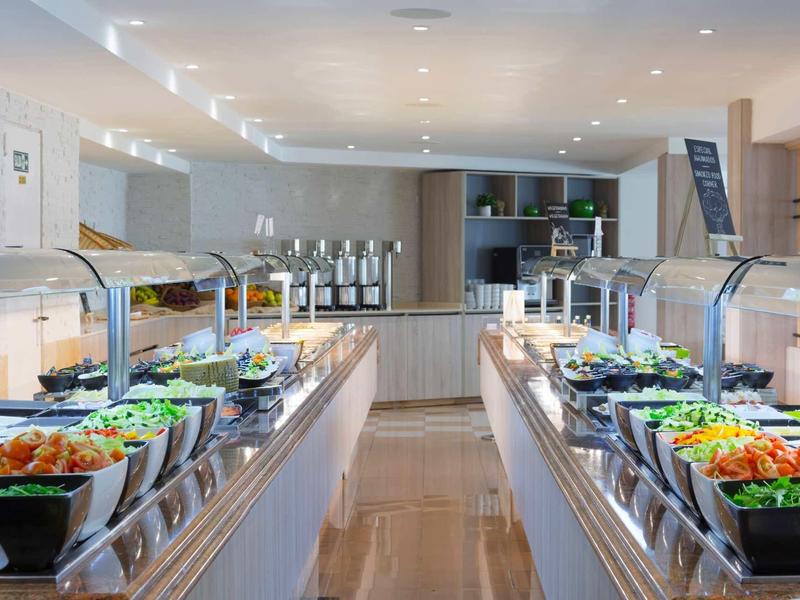 Buffet lumineux avec salades fraîches et légumes dans des bols en verre sur deux comptoirs.