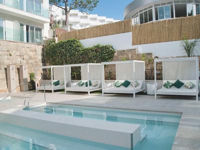 Nowoczesny basen na zewnątrz z białymi leżakami w luksusowym hotelu.