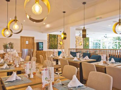 Bright, modern restaurant with round pendant lights and set tables.