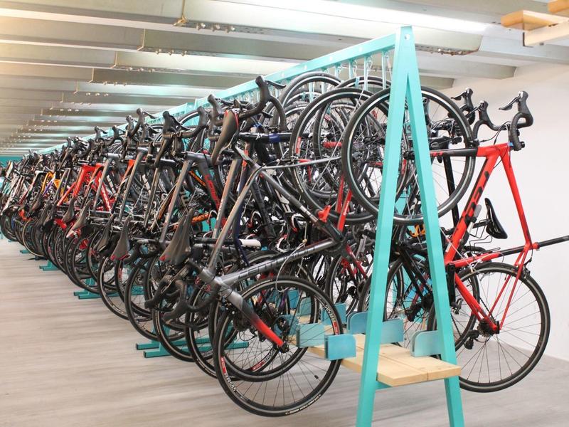 Biciclette parcheggiate ordinatamente su un rastrelliera blu a due piani al chiuso