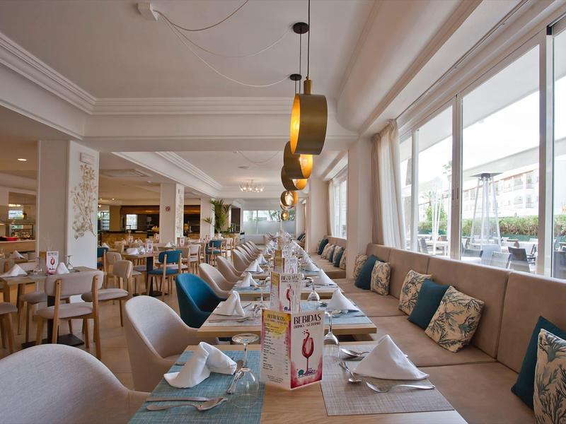 Ristorante elegante con tavoli moderni, sedie e grandi finestre che guardano all'esterno.