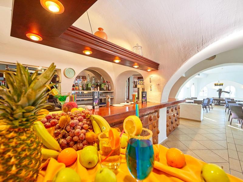 Colorful fruit display and bar in a bright, open hotel restaurant area.