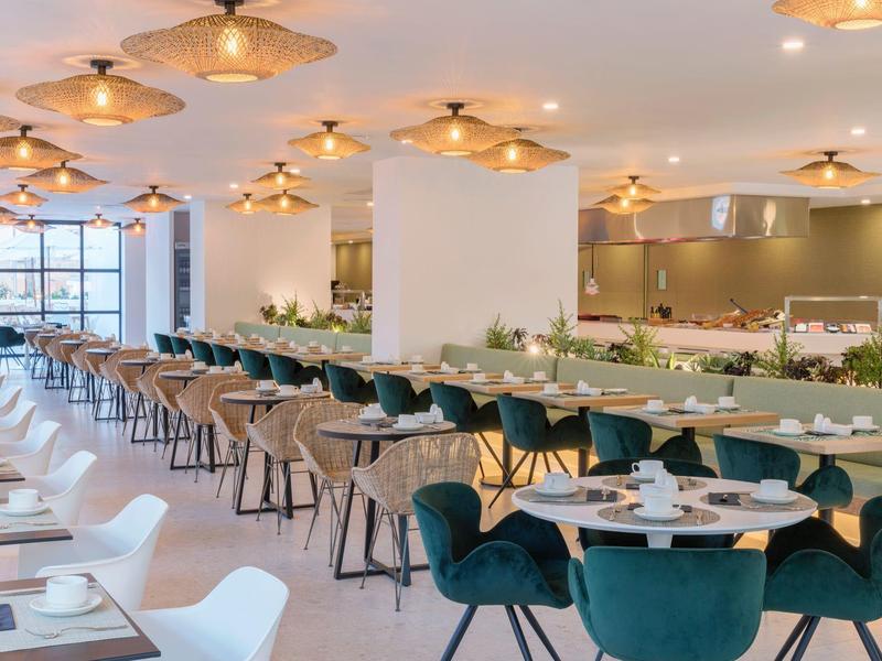 Ristorante moderno con sedie verdi e bianche eleganti e illuminazione calda.