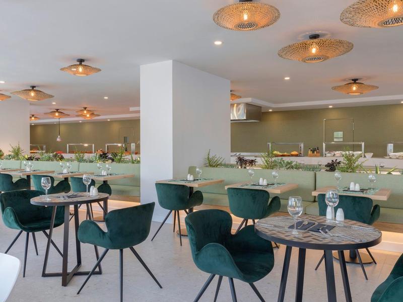 Sala da pranzo moderna con sedie verdi e tavoli apparecchiati in un ristorante di stile.