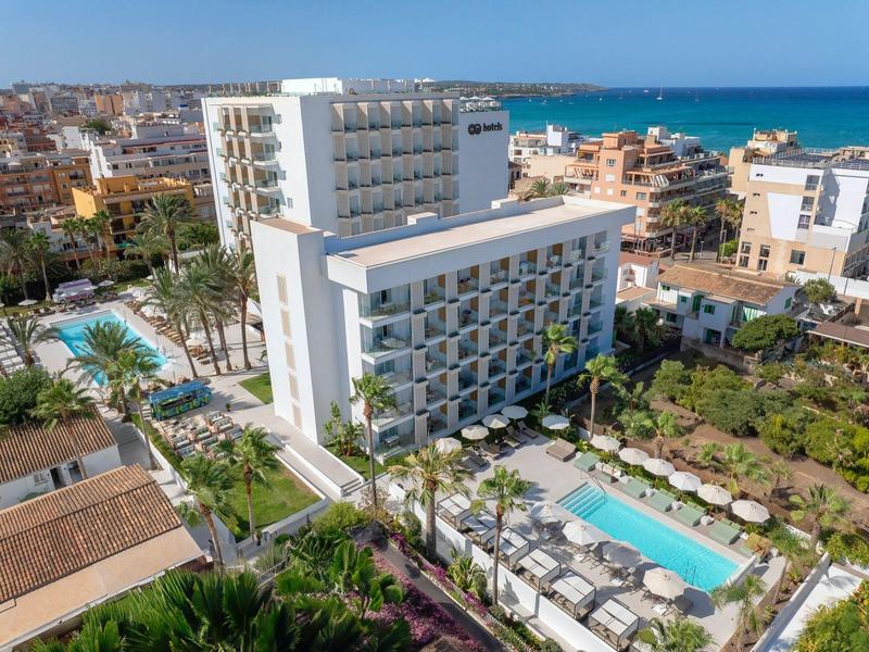 Hotel moderno con piscine e vista sul mare vicino in un paesaggio urbano.