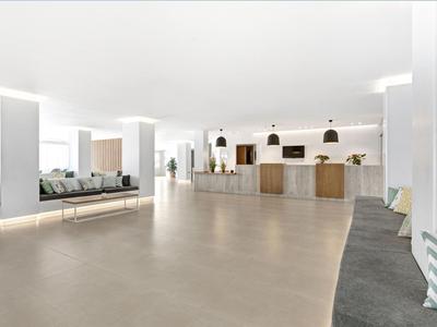 Helle, moderne Hotellobby mit Sitzbänken und Rezeptionsbereich in einer offenen Gestaltung.