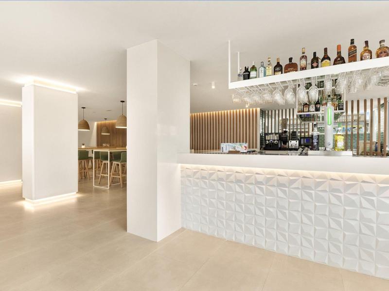 Moderner, heller Barbereich mit minimalistischer Einrichtung und dekorativer, weißer Front.