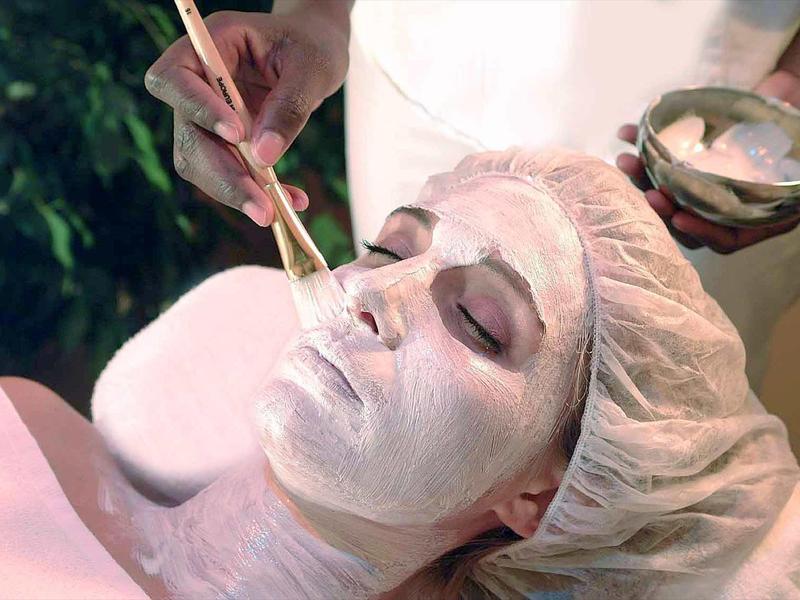 Woman receiving facial mask application during a spa treatment.