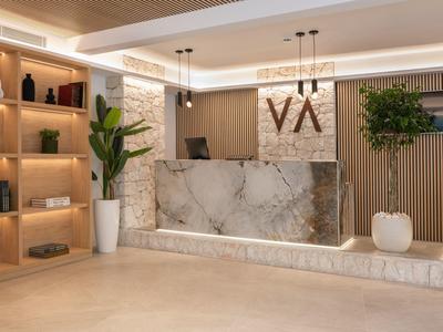Modern reception area with marble front desk, plants, and decorative shelves.