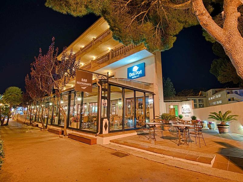 Oświetlona restauracja hotelowa z miejscem na zewnątrz i drzewami nocą