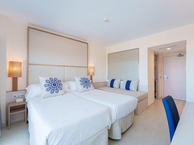 Modernes Hotelzimmer mit zwei Einzelbetten, bequemen Kissen und heller Einrichtung.