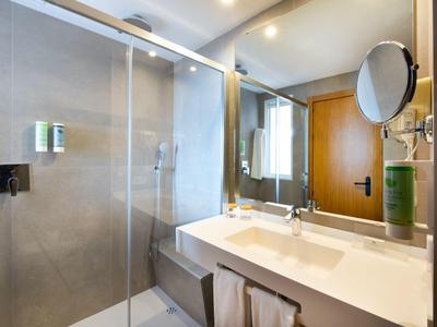 Modernes Badezimmer mit begehbarer Glasdusche und Doppelwaschbecken.