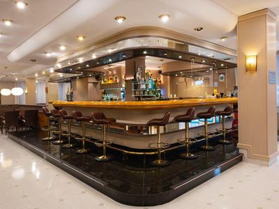 Moderner Hotelbarbereich mit langen Hockern und indirekter Beleuchtung