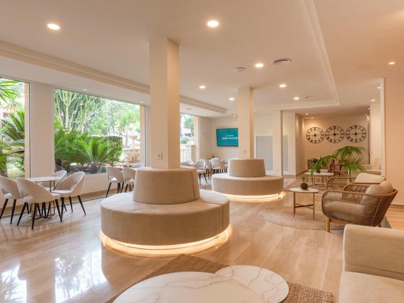 Modernes, helles Wartzimmer mit runden Sitzinseln, großen Fenstern und bequemen Sesseln.