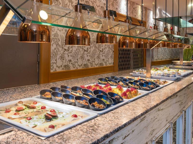 Buffet mit verschiedenen frischen Meeresfrüchten auf einem Marmortresen unter warmem Licht