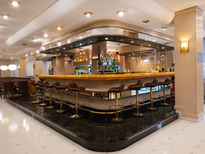 Moderner Hotelbarbereich mit langen Hockern und indirekter Beleuchtung