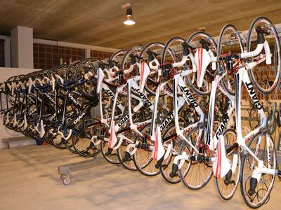 Più bici da corsa ordinate all'interno su un supporto per biciclette.