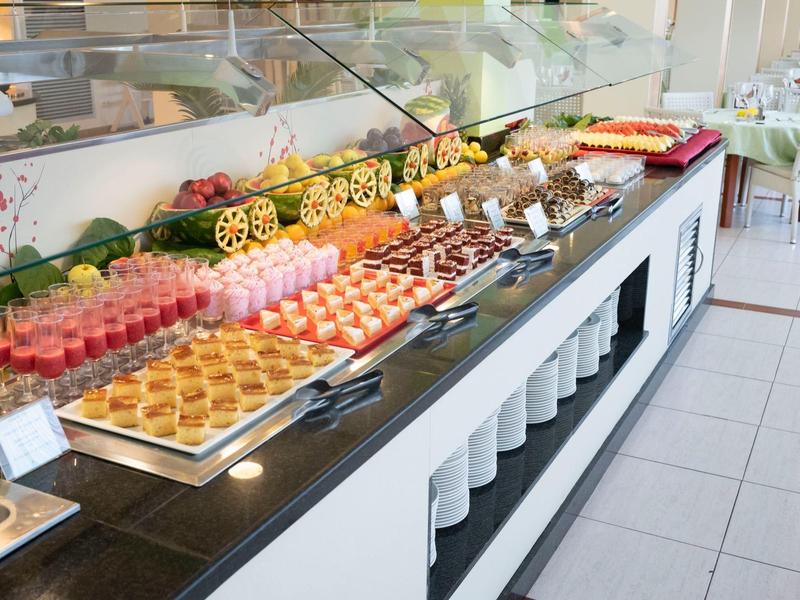 Buffet con diferentes platos dulces y salados en un comedor luminoso.