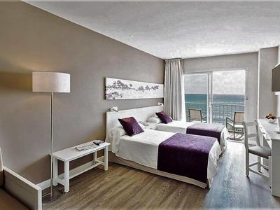 Nowoczesny pokój hotelowy z widokiem na morze i podwójnym łóżkiem.