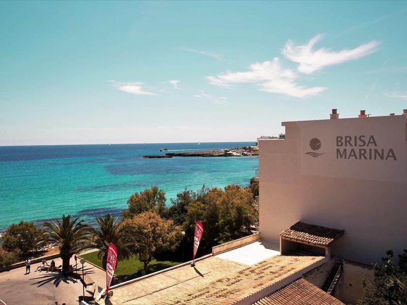 Widok na morze i budynek hotelu Brisa Marina na wybrzeżu przy niebieskim niebie.