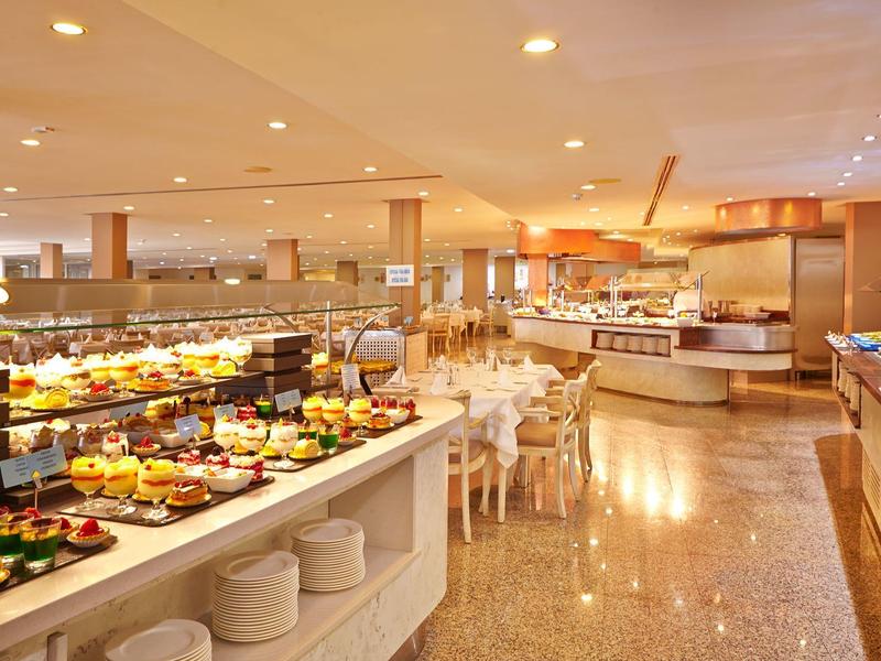 Großer Frühstücksraum mit Buffet, Tischen und Stühlen, hell und modern gestaltet.