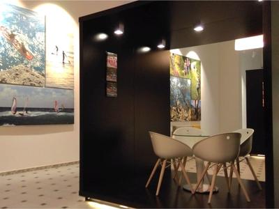 Modern room with black partition, chairs, and decorative wall pictures.