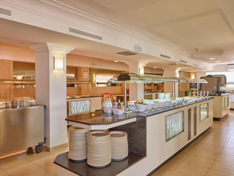 Area buffet con cibo e piatti in un ristorante d'hotel luminoso e moderno.