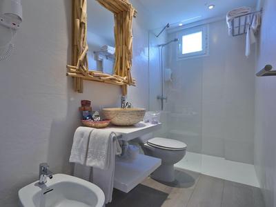 Moderne badkamer met douche, toilet, bidet en spiegel met houten lijst.