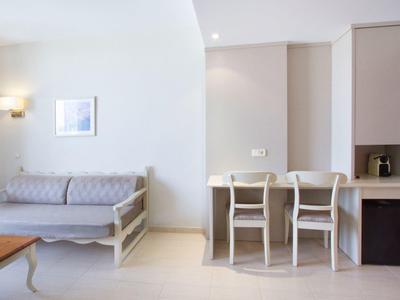 Světý pokoj s pohovkou, stolem a třemi židlemi u malého jídelního koutu.