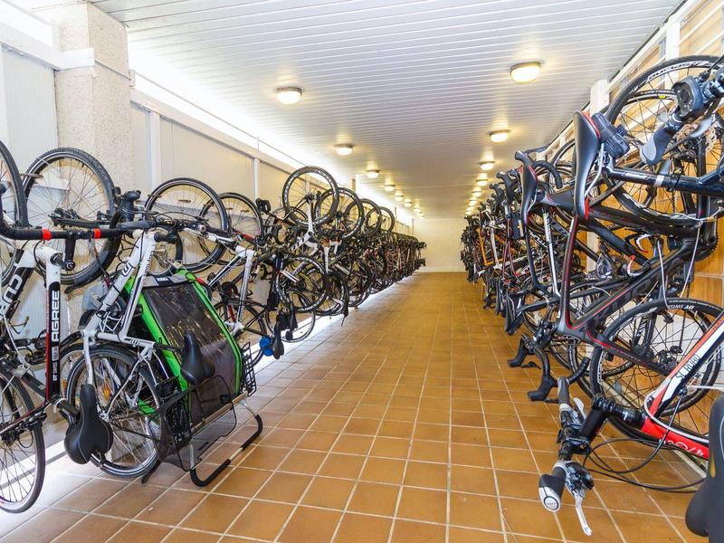 Bike storage room with two rows of hanging bicycles in a hotel