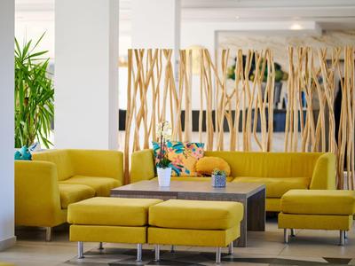 Modern eingerichteter Hotel-Loungebereich mit gelben Sesseln und dekorativen Holzelementen