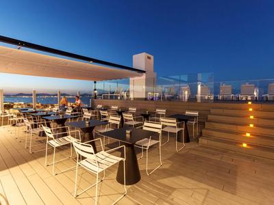 Ruim dakterras met zitplaatsen, trappen en een heldere avondlucht bij een hotel.