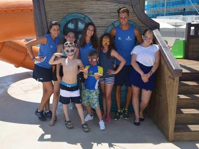 Skupina dospělých a dětí před vodní skluzavkou v běžném oblečení.