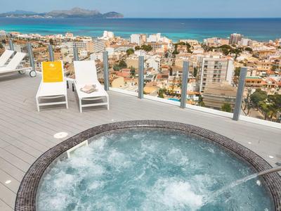 Vírivka na střešní terase s výhledem na moře a město pod ní.