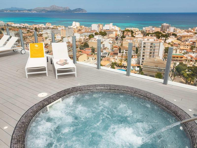 Vírivka na střešní terase s výhledem na moře a město pod ní.