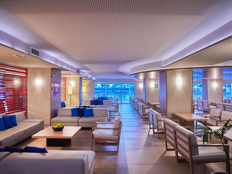 Modern eingerichteter Hotel-Loungeraum mit Sitzbereichen und Blick auf das Meer.