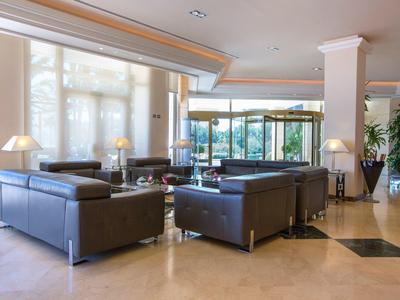 Moderne Lounge mit Ledersofas und großen Fenstern in hellem Hotelbereich.