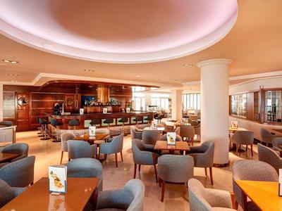 Modernes Restaurant mit gemütlichen Sesseln und Holztischen in einem Hotel.