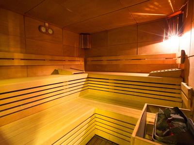 Helle, entspannende Sauna mit Holzbänken und warmem Licht.