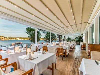 Restaurant lumineux avec des tables blanches et vue sur l'eau.