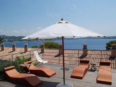 Terraza con tumbonas y sombrilla con vistas al mar y a las islas.