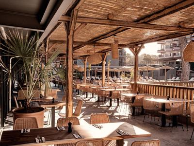 Accogliente terrazza del ristorante con mobili in legno e tetti in bambù.