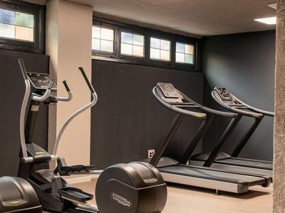 Palestra moderna con tapis roulant e cross trainer in un hotel.
