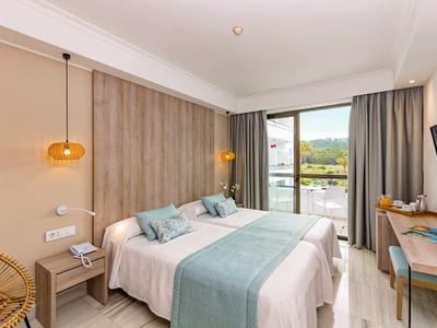 Camera d'hotel moderna con due letti, parete di legno, grande finestra e vista sul paesaggio.