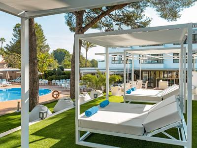 Hotel moderno con piscina e comodi letti bianchi all'aperto