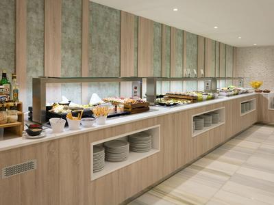 Modern hotelbuffet met diverse ontbijtopstellingen op een lange houten toonbank.