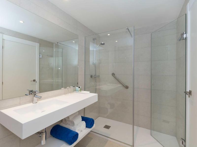 Bagno bianco moderno con doppio lavabo e doccia walk-in.