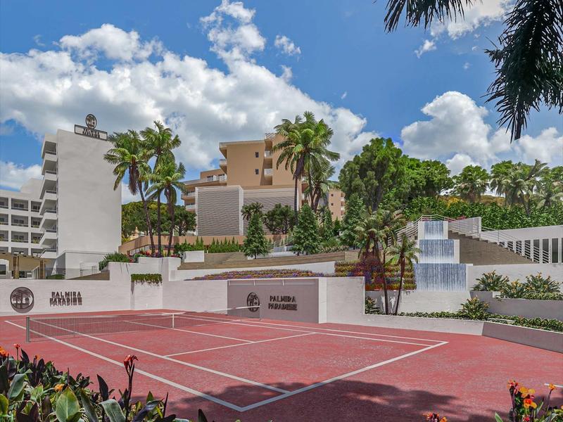 Campo da tennis in un resort tropicale con palme e piante fiorite