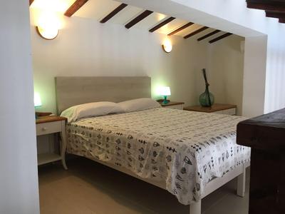 Schlafzimmer mit Doppelbett, Nachttischen und sanfter Beleuchtung in gemütlichem Hotelzimmer.